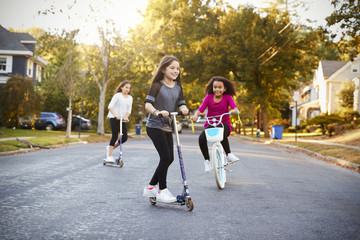 Kids riding scooters and bikes on a quiet Gwinnett County neighborhood street