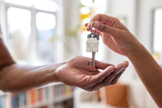 Handing over house keys with a home keychain